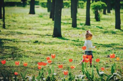 Маленькая девочка гуляет рядом с тюльпанами в дендропарке Кропивницкого