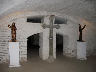 Крест и скульптуры монахов в подземелье монастыря капуцинов в Остроге