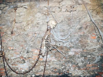 Кістки людського скелету на ланцюгах у казематах Дубенського замку