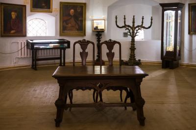 Дерев'яний стіл зі стільцями та картини у Острозькому замку