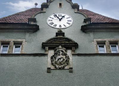 Герб Шенборнів та годинник на фасаді палацу в Карпатах