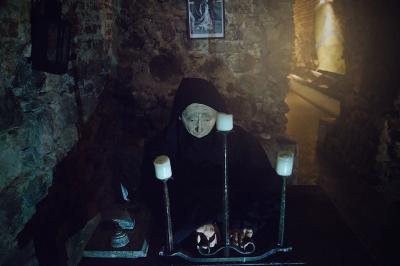 Фігура монаха за столом у підземеллі Ужгородського замку